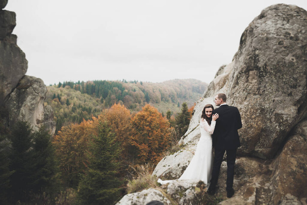 Happy wedding couple posing over beautiful landscape in the mountains. - Fotoğraf, Görsel