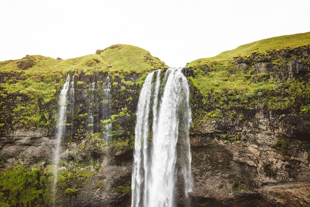 Gljufrafoss lub Gljufrabui, wodospad, mały wodospad ukryty na wąskim kanionie w pobliżu bardziej znanego Seljalandsfoss, południowej Islandii. Wysokiej jakości zdjęcie. - Zdjęcie, obraz