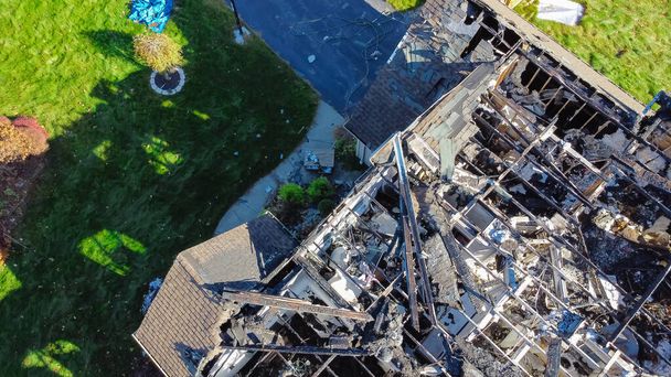 空中からの眺めは、米国ニューヨーク州ロチェスターの2階建ての単一の家族の家の2階建ての屋根を破壊した家を焼きました。火災災害により全壊した住宅、保険金請求の背景 - 写真・画像