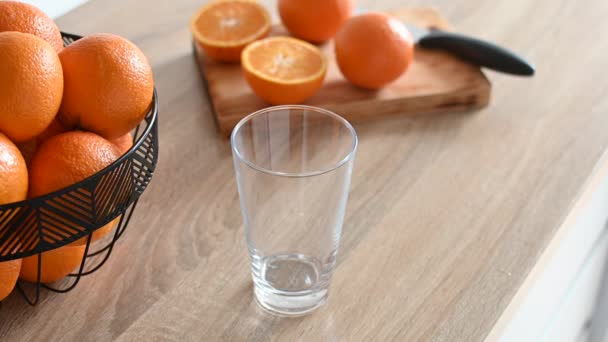  Uomo versando succo d'arancia in un bicchiere in cucina - Filmati, video