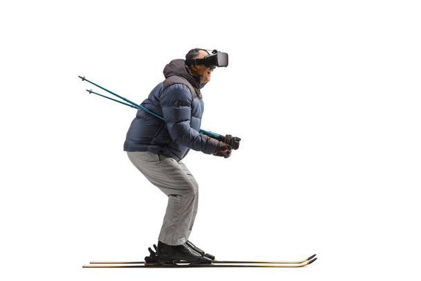 Full length profile shot of a mature man skiing with vr headset isolated on white background - Fotografie, Obrázek