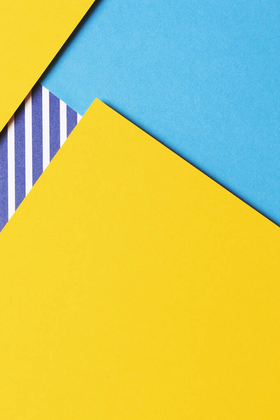 Abstract geometric fashion colored papers texture background. Yellow, light blue and striped white and blue color paper background. Top view, flat lay. - Photo, Image