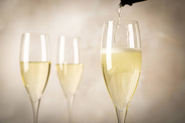 Festive photo of pouring sparkling wine into glasses - Foto, Imagen