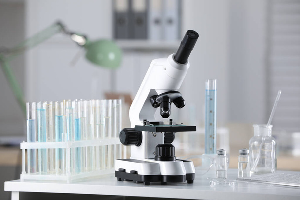 Modern medical microscope on white table in laboratory - 写真・画像