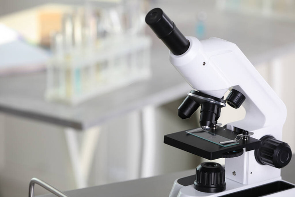 Modern medical microscope on metal table in laboratory, space for text - Photo, Image