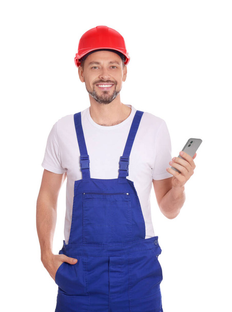 Professional repairman in uniform with phone on white background - 写真・画像