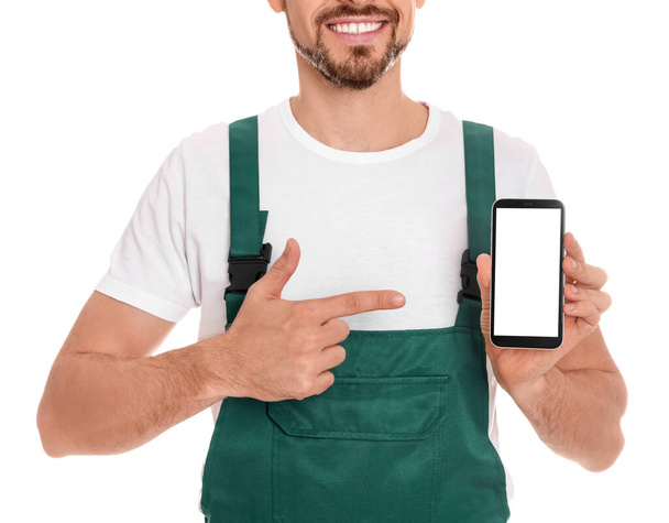 Professional repairman in uniform with phone on white background, closeup - Foto, imagen