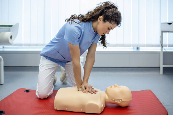 CPR-Kurs mit Instruktoren, die Erste Hilfe, Kompressionen und Reanimation vorführen. Cpr-Attrappe - Foto, Bild