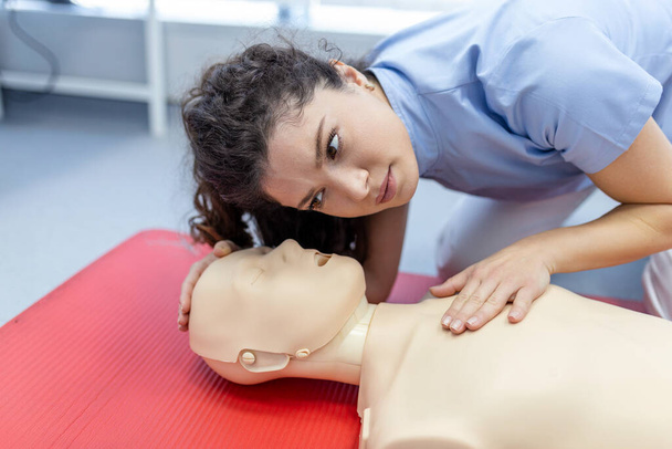 vrouw oefenen cpr techniek op dummy tijdens eerste hulp training. Eerstehulptraining - cardiopulmonale reanimatie. EHBO-cursus over dummy 's. - Foto, afbeelding