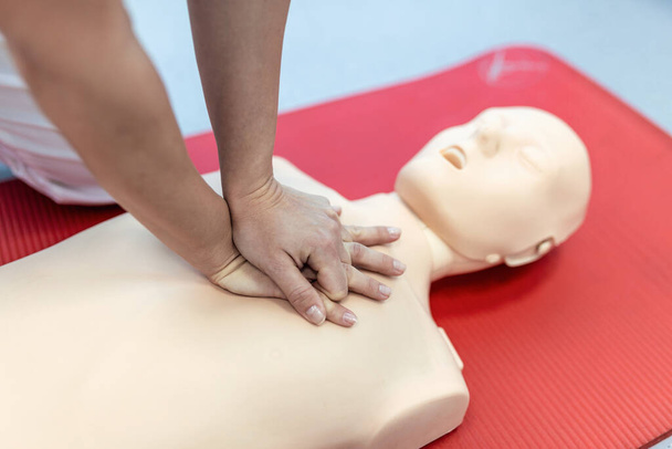 CPR class with instructors talking and demonstrating firt aid, compressions ans reanimation procedure. Cpr dummy - 写真・画像
