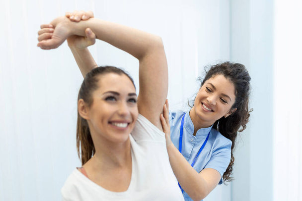 Doctor or Physiotherapist working examining treating injured arm of athlete patient, stretching and exercise, Doing the Rehabilitation therapy pain in clinic. - Photo, Image