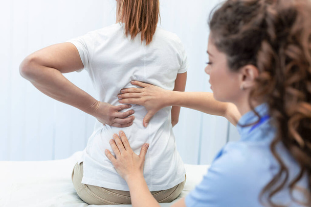 Fisioterapeuta haciendo tratamiento curativo en mujeres espalda. Dolor de espalda paciente, tratamiento, médico, masajista. - Foto, imagen