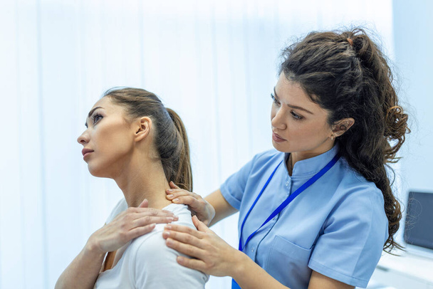 Woman doctor osteopath in medical uniform fixing woman patients shoulder and back joints in manual therapy clinic during visit. Professional osteopath during work with patient concept - Photo, Image