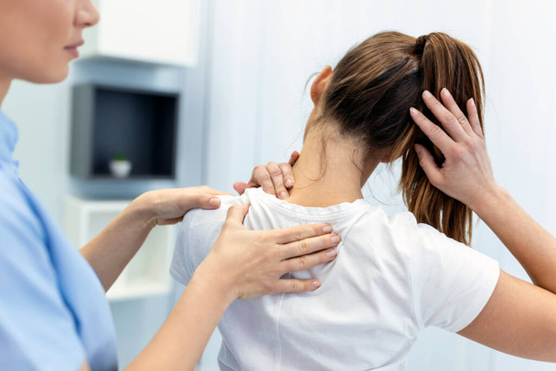 Жінка-лікар остеопат в медичній формі фіксує пацієнток плечового і спинного суглобів в клініці мануальної терапії під час візиту. Професійний остеопат під час роботи з концепцією пацієнта
 - Фото, зображення