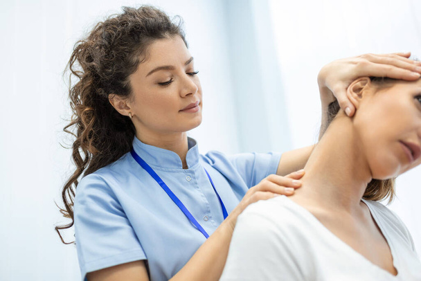 Fisioterapeuta haciendo tratamiento curativo en el cuello de las mujeres, ajuste quiropráctico, concepto de alivio del dolor.síndrome de oficina - Foto, Imagen