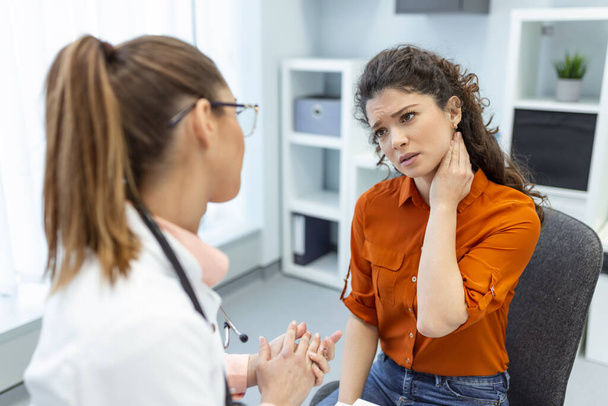 Woman having a neck pain. Doctor working in the office and listening to the patient, she is explaining her symptoms, healtcare and assistance concept - Photo, image