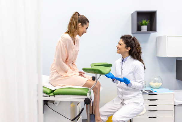 Gynécologue parlant avec une jeune patiente lors d'une consultation médicale dans une clinique moderne. Patient avec un gynécologue lors de la consultation au cabinet gynécologique - Photo, image