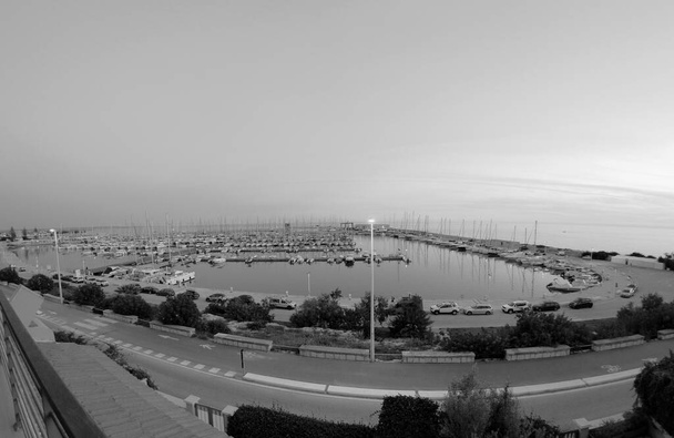 Италия, Сицилия, Средиземное море, Марина ди Рагуза (провинция Рагуза); моторные лодки и роскошные яхты в порту на закате  - Фото, изображение