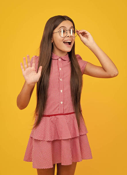 Amazed teen girl. Teenager child with poor eyesight wear eyeglasses, looking squinting. Kids glasses. Funny surprised adorable girl in round glasses having astonished shocked facial expression - Foto, afbeelding