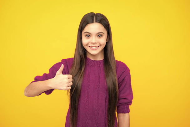 Like it. Portrait of joyful teenage child girl showing thumbs up and smiling, yellow background with copy space - Foto, immagini