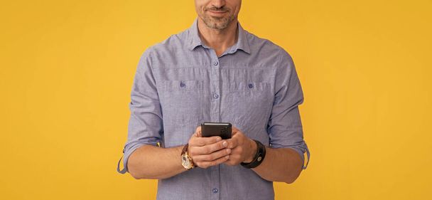 smiling man chatting on phone on yellow background, chat. - Foto, Imagen