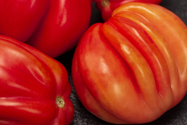 Red tomatoes close up. Top vew. Black background. - Фото, зображення