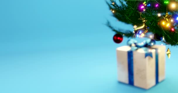 С Новым годом подарок украшает голубой фон и ветку елки мерцающие гирлянды лампочки для семейного праздника. Фестивальное настроение. Позитивные эмоции - Кадры, видео