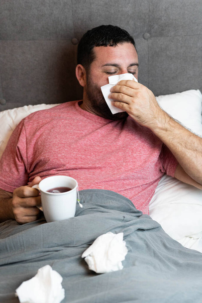 Muž středního věku v posteli nemocný s příznaky chřipky - Fotografie, Obrázek