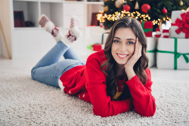 Photo of young excited cute pretty lovely relaxed satisfied girl chill celebrate weekend christmas atmosphere touch cheeks lying carpet indoors. - Фото, изображение