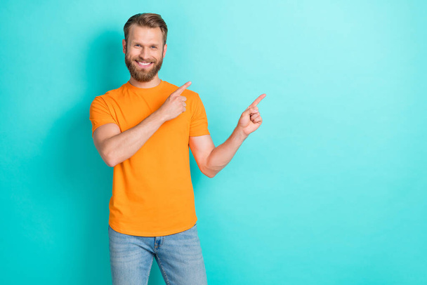 Photo of optimistic brown hairdo guy index promo wear orange t-shirt isolated on teal color backgroiund. - Фото, изображение