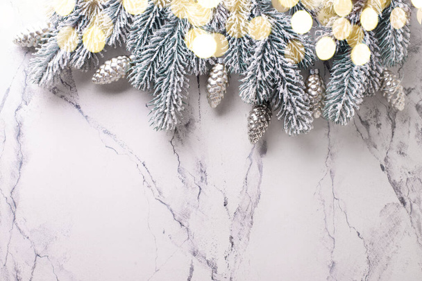 Határ ágak, ezüst üveg kúpok és bokeh fények d fehér csoda háttér. Egyszerű karácsonyi kompozíció. Első látásra. A szöveg helye. - Fotó, kép