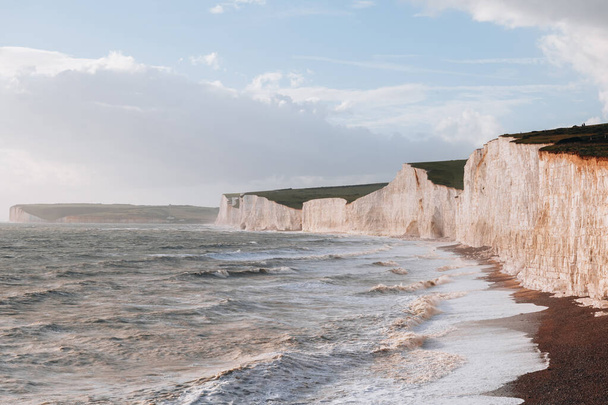 Olas golpeando la playa por los acantilados de tiza de Seven Sisters, uno de los tramos más largos de costa subdesarrollada en la costa sur, East Sussex, Reino Unido. - Foto, Imagen