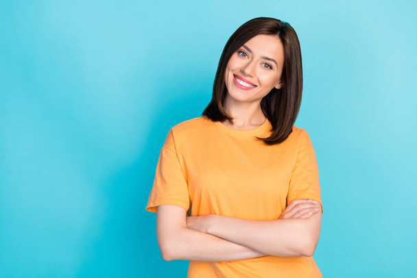Photo of pretty cute optimistic lady arm folded wear orange trendy clothes empty space isolated on blue color background. - Фото, зображення