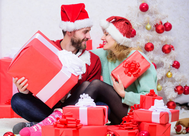 Couple in love enjoy christmas holiday celebration. Woman and bearded man wear santa claus hat christmas tree background. Christmas eve with darling. Family married couple at home. Love is best gift. - Foto, Imagen