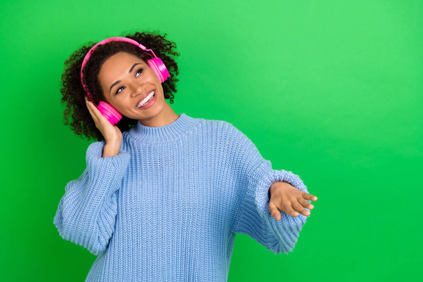 Photo of lovely pretty girl arm touch headphones enjoy new playlist isolated on green color background. - Foto, imagen