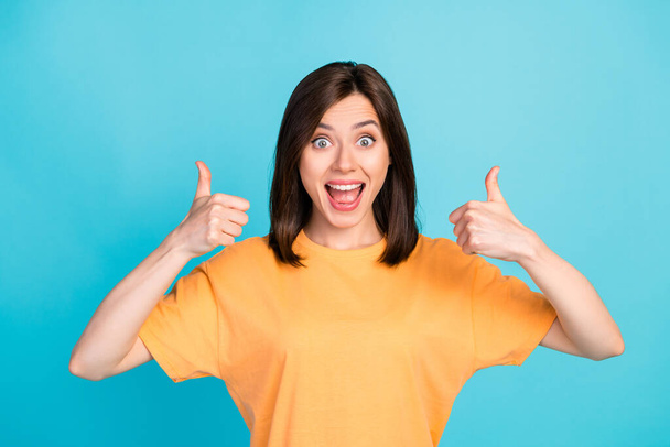 Photo of crazy impressed overjoyed girl straight hair wear yellow t-shirt showing thumbs up open mouth isolated on blue color background. - Foto, imagen