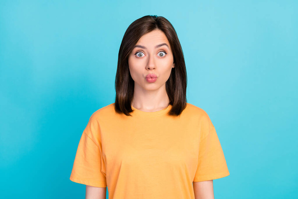 Photo of nice cute astonished girl with straight hairdo wear yellow t-shirt staring pouted lips kiss isolated on blue color background. - Valokuva, kuva