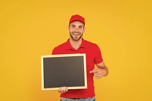 male behind chalkboard. place for useful information. advertisement copy space. your marketing design. fast delivery. cheerful man in cap with blackboard. guy make announcement. - Foto, immagini