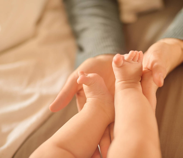 最小の足は私たちの心の中で最大の足跡を残します。赤ん坊の足を持つ正体不明の母親が - 写真・画像