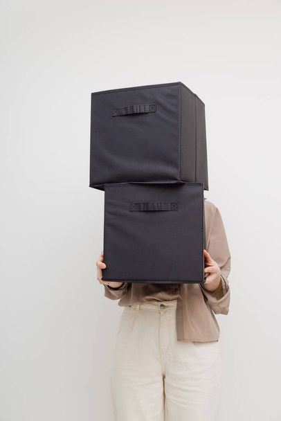 Woman holding boxes for closet organization or moving house. Faceless. - Foto, Bild