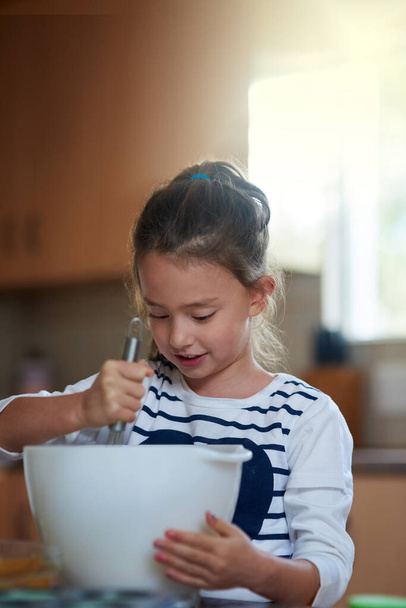 Trying her hand at baking. a little girl baking in the kitchen - Фото, зображення