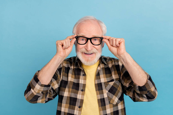 Photo of funny charming retired man wear plaid shirt arms spectacles smiling isolated blue color background. - Foto, Bild