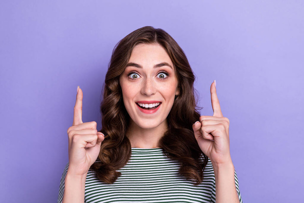 Portrait photo of young crazy woman girl directing fingers up shocked great offer proposition sale clothes isolated on pastel purple color background. - Фото, зображення