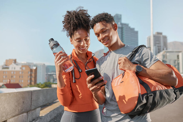 Smartphone, fitness και μαύρο ζευγάρι στην πόλη για προπόνηση προπόνηση mobile app, social media και πληροφορίες ιστοσελίδα. Χαρούμενα νεαρά αθλήματα, αθλητής ή επιλαχόντες φίλοι που χρησιμοποιούν το τηλέφωνο σε αστικό δρόμο. - Φωτογραφία, εικόνα