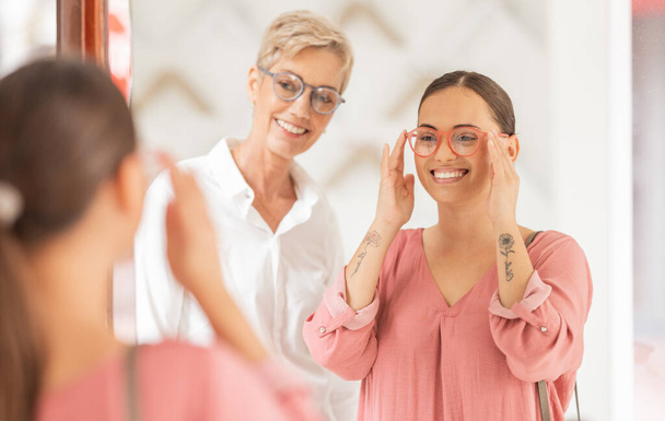 Lustro, okulary i optyk z kobietą i lekarzem do konsultacji, wzroku i opieki oczu. Sprzedaż detaliczna, zakupy i ubezpieczenie wraz z konsultantem i klientem w sklepie w zakresie opieki zdrowotnej, optometrii lub medycyny. - Zdjęcie, obraz