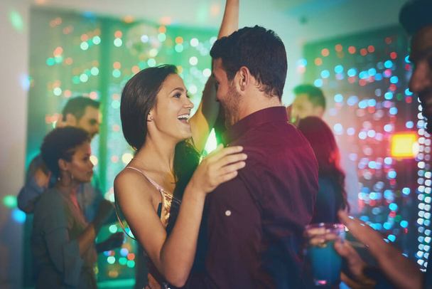 Moved by the music. an affectionate young couple dancing on a crowded dance floor in a nightclub - Foto, Imagem