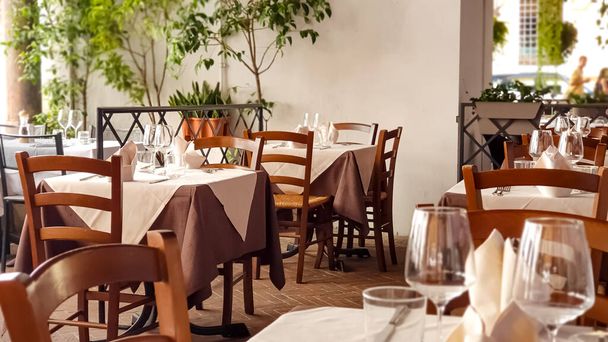 ワイングラス、ナプキン、カトラリー付きのおしゃれなレストランで用意されたテーブル - 写真・画像