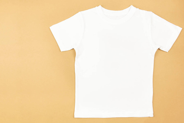 White womens cotton tshirt mockup on craft paper background. Design t shirt template, print presentation mock up. Top view flat lay.  - Fotografie, Obrázek