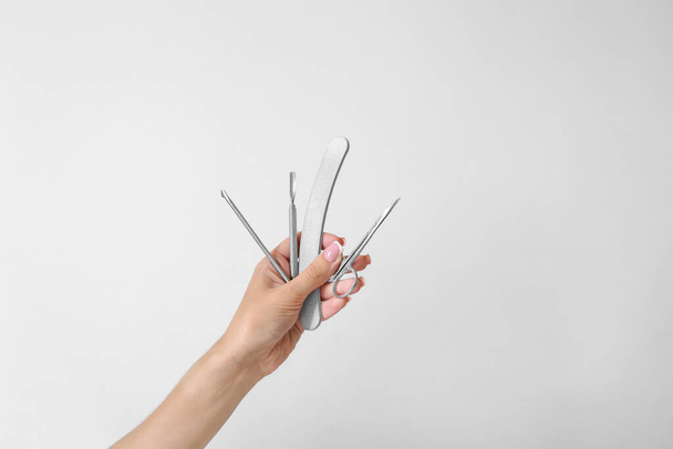 close up of woman hands holding manicure tools on a white background - Фото, зображення