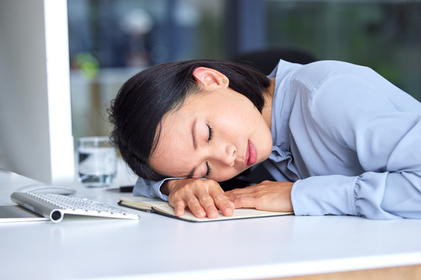 Burnout, moe en zakenvrouw slapen op het bureau in haar moderne kantoor, terwijl het plannen van een strategie. Vermoeidheid, overwerkt en professioneel personeel dat tijdens het werk aan een project een dutje doet. - Foto, afbeelding